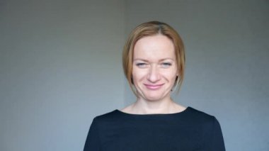 Dramatik yakın kadar güzel sarışın kadının parlak mavi gözler portre ağır çekim yumuşak doğal ışık yüz merkezi bir ürün üzerinde gülümseyen mutlu ile o kafasını sözleşmesinde sallıyor ve gülümsüyor
