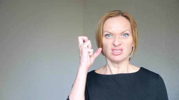 4k. Close-up of a beautiful blonde with bright blue eyes. Portrait of a young woman. sign language and gestures. she gets angry and yells at the camera — Stock Video