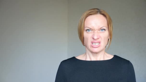 4k. Close-up of a beautiful blonde with bright blue eyes. Portrait of a young woman. sign language and gestures. she gets angry and yells at the camera — Stock Video