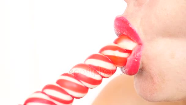 Sexy meisje eten een lolly. simulatie van orale seks. tong likken snoep. 4 k, vertraagd, close-up. kopie ruimte — Stockvideo