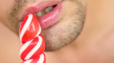seksi bir adam bir lolipop yemek. oral seks simülasyonu. şeker, 4 k, ağır çekim yalama dil. kopya alanı