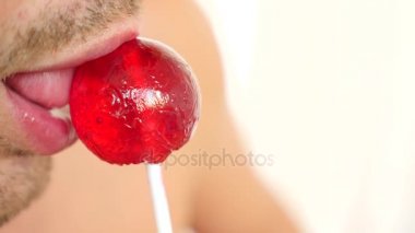 seksi bir adam bir lolipop yemek. oral seks simülasyonu. şeker, 4 k, ağır çekim yalama dil. kopya alanı