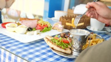 romantik bir çift, bir açık kafe Yunan yemekleri yemek kahvaltı souvlaki ve bir Yunan. 4k, ağır çekim