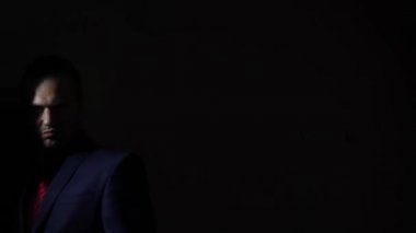 Karanlıkta silahını çekerek ve kameraya hedefleyen bir adam. 4k, ağır çekim