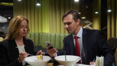 İş ortakları erkek ve kadın kafe kullanım smartphones vasıl öğle yemeği. 4 k kopya alanı