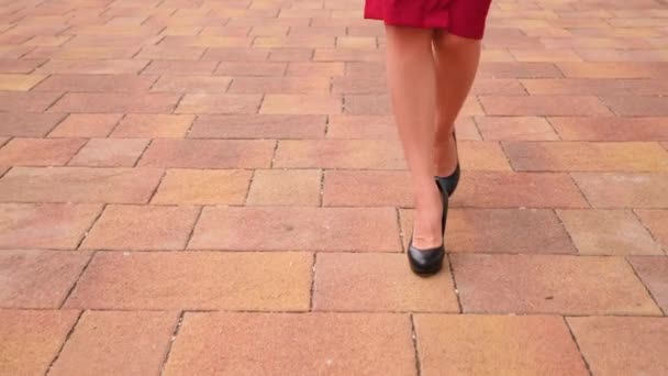 Vrouwelijke benen in hoge hakken close-up. 4k, Slowmotion, rode kokerrok — Stockvideo