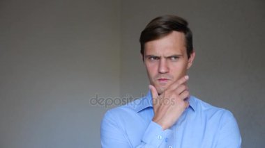 4 k. ağır çekim. Genç bir adam portresi kapatın. beden dili ve hareketleri. o düşünüyor, bir karar verir