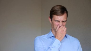 4 k. ağır çekim. Genç bir adam portresi kapatın. beden dili ve hareketleri. tiksinti ve burnunu kapatır. koku