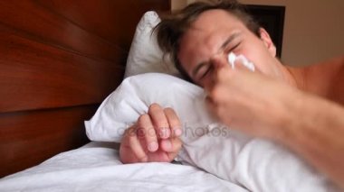 Ateşi olan bir adam evde yatakta yatıyor. 4k, ağır çekim