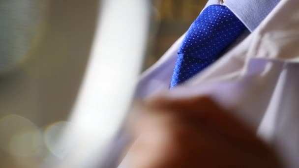 A man in a business suit and tie is putting on a white robe. 4k, slow motion — Stock Video