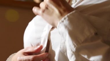 yakın çekim, ayrıntılar. bir kadın onun beyaz gömlek üzerinde üst düğmesini unfastens, onu kaldırır. 4k, ağır çekim