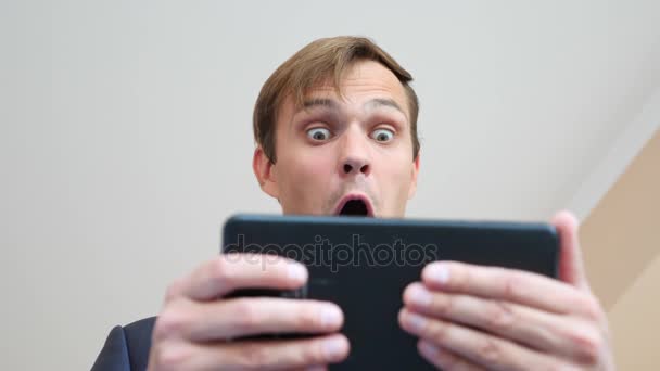 4 k. Slow-motion. jonge man kijkend naar de tablet verbaasde ogen macro close-up, — Stockvideo