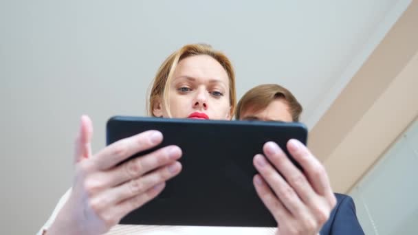 4k. En cámara lenta. joven mujer y hombre mirando la tableta ojos sorprendidos macro primer plano , — Vídeos de Stock