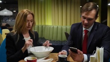 İş ortakları erkek ve kadın kafe kullanım smartphones vasıl öğle yemeği. 4 k kopya alanı