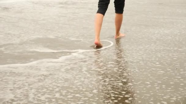 女商人在西装站在海滩上。她喜欢的海景。4 k，慢动作。脚在波浪中的关闭 — 图库视频影像