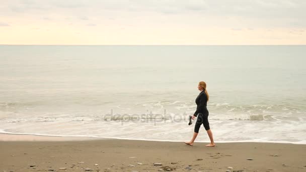 Donna d'affari in giacca e cravatta in piedi sulla spiaggia. si gode la vista sul mare. 4k, rallentatore . — Video Stock