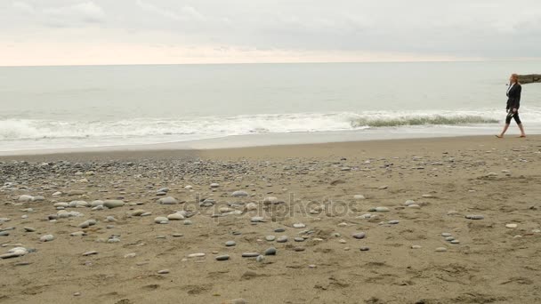 女商人在西装站在海滩上。她喜欢的海景。4 k 慢动作. — 图库视频影像