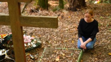 bir kadında mezarlığa mezarın yanında siyah bir bluz. 4k, ağır çekim. kopya alanı