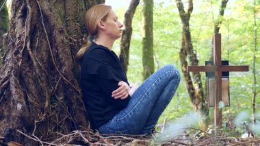 bir kadında mezarlığa mezarın yanında siyah bir bluz. 4k, ağır çekim. kopya alanı