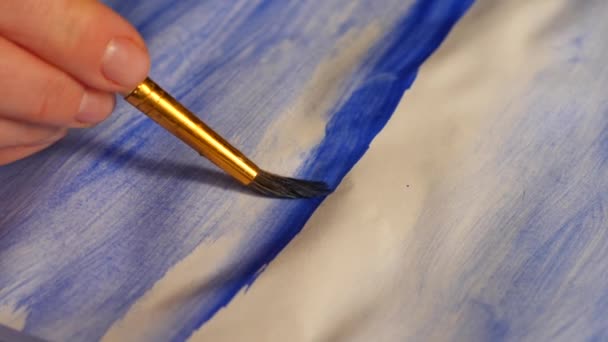 L'artista dipinge vernici su un foglio bianco. primo piano di un nappa. 4k, ripresa al rallentatore — Video Stock