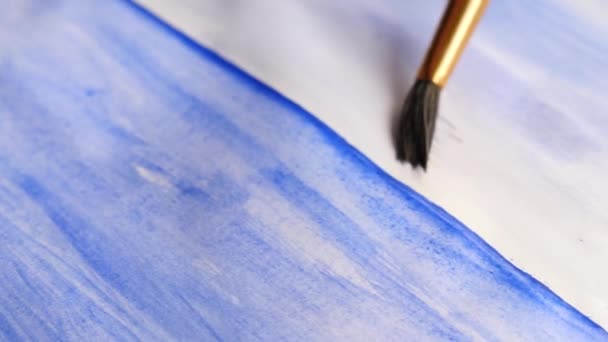 Konstnären målar färger på ett vitt ark. närbild av en tofs. 4k, Slowmotion-skytte — Stockvideo