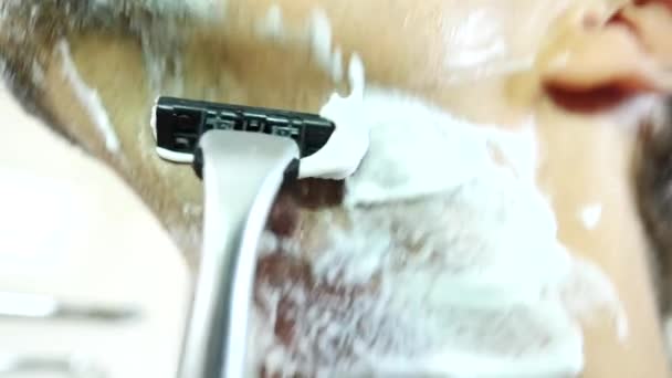 Man shaves his face. handsome man shaving in the bathroom. 4k, slow motion. close-up — Stock Video