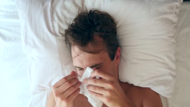 Un bărbat cu febră stă în pat acasă. 4k, mișcare lentă — Videoclip de stoc