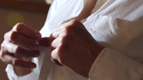 Zbliżenie, szczegóły. Kobieta, zapinane na guziki przycisk u góry na białą koszulę. 4k, zwolnionym tempie — Wideo stockowe