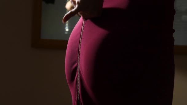 Les doigts féminins détachent la fermeture éclair sur une jupe rouge. culotte visible et les fesses. Gros plan, détails. 4k, au ralenti — Video