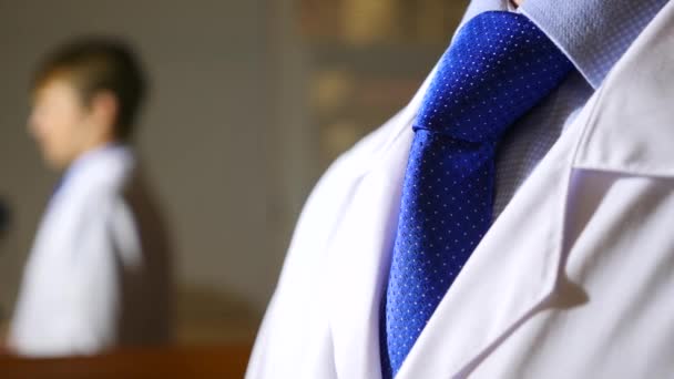 Человек в деловом костюме и галстуке снимает белый халат. 4k, slow motion — стоковое видео