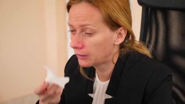 Femme d'affaires malade avec la grippe qui se mouche dans les tissus. dans le bureau. 4k, au ralenti — Video