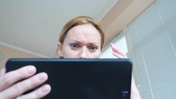 4k. Zeitlupe. Junge Frau blickt überrascht zum Tablet auf, — Stockvideo