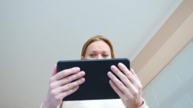 4 k. ağır çekim. genç kadın tablet vasıl bakarken gözleri makro yakın çekim şaşırttı,