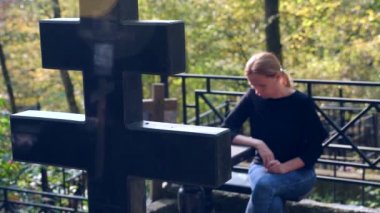 bir kadında mezarlığa mezarın yanında siyah bir bluz. 4k, ağır çekim. kopya alanı