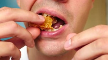 yakın çekim, adam yiyor, fast food, tavuk nuggets, kanatları ve patates kızartması.
