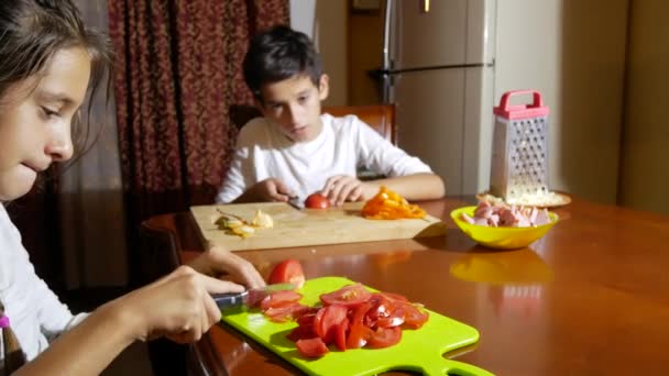 Irmão e irmã cortaram um recheio para pizza. cozinhando pizza, a família está cozinhando na cozinha. 4k — Vídeo de Stock