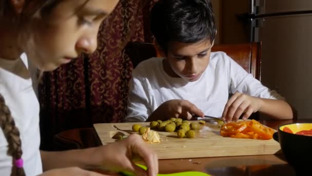 Hermano y hermana cortaron un relleno para pizza. cocinar pizza, la familia está cocinando en la cocina. 4k — Vídeos de Stock