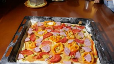 yakın çekim, eller üzerinde hamur pizza için dolgu yayıldı. pişirme pizza, Aile mutfakta yemek pişiriyor. 4k
