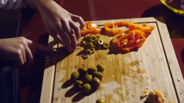 yakın çekim. kız ve erkek kardeşim bir dolgu pizza için kesti. pişirme pizza, Aile mutfakta yemek pişiriyor. 4k