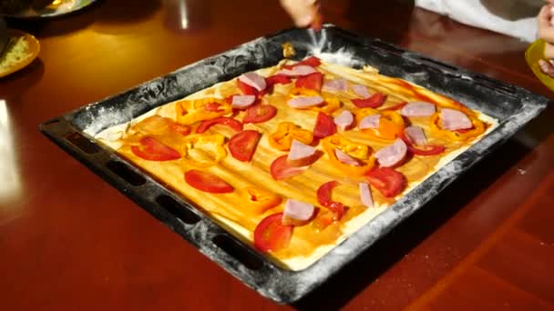 Detail, ruce šíří náplň na těsto na pizzu. vaření pizza, rodina je vaření v kuchyni. 4k — Stock video