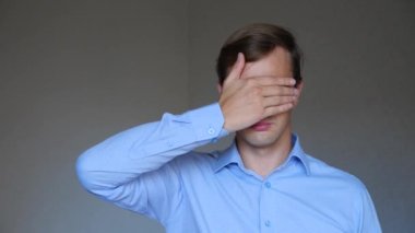 4 k. yakın çekim. genç bir adam portresi. beden dili ve hareketleri. elleriyle gözlerini kapatır, görmek istiyorum değil.