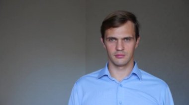 4 k. yakın çekim. Genç bir adam portresi. işaret dili ve jestleri. o eliyle ağzını kapsar ve sessiz tutar