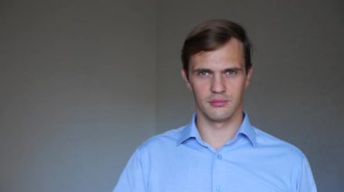 4 k. yakın çekim. Genç bir adam portresi. işaret dili ve jestleri. o eliyle ağzını kapsar ve sessiz tutar