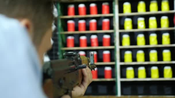 Joven dispara en un tablero de juego de un rifle de asalto Kalashnikov, 4k, airsoft — Vídeos de Stock