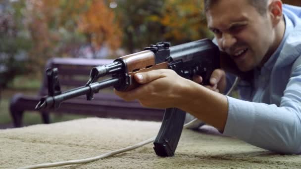 Jonge man schiet in een toneelstuk dash uit een Kalashnikov assault rifle, 4k, airsoft — Stockvideo