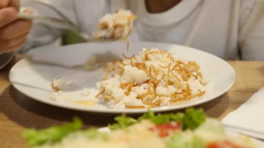 Çocuk köri pirinç ile Domuz pirzola yiyor. 4k