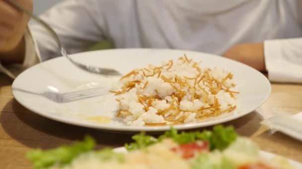 Il bambino sta mangiando riso al curry con cotoletta di maiale. 4k — Video Stock