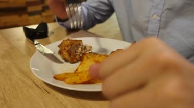 adam kızarmış et pirzola ile kavrulmuş baharat patates yiyor. 4k.