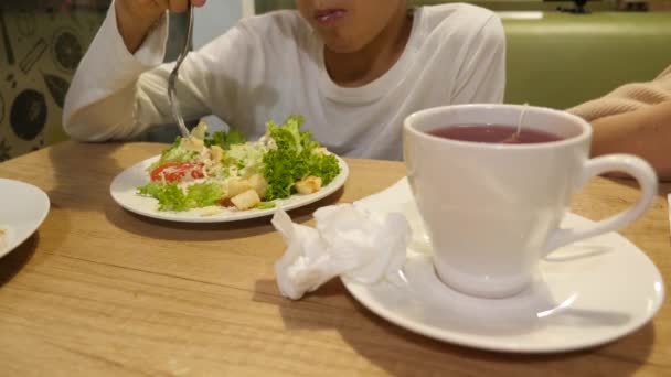 Un chico está comiendo ensalada César por tenedor. 4k — Vídeos de Stock