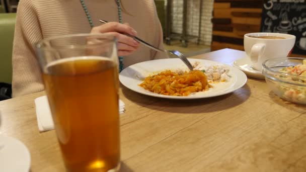 Kvinna äta köttbullar med bräserad kål i en keramisk platta. i caféet. 4k — Stockvideo